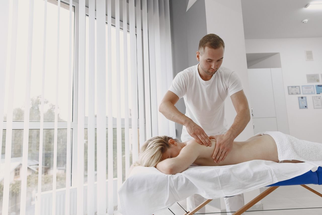 A massage therapist provides a relaxing back massage in a modern clinic setting.